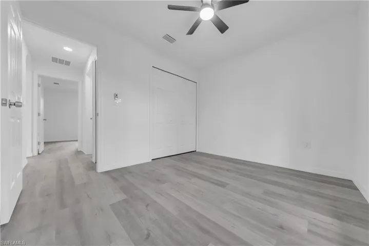 Unfurnished bedroom with a closet, ceiling fan, and light wood-type flooring