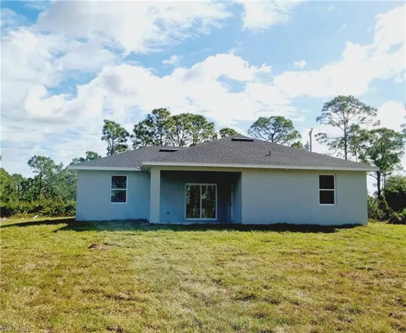 Back of property featuring a lawn