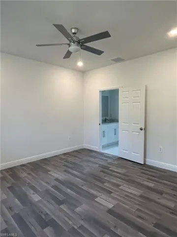 Spare room featuring dark hardwood / wood-style floors and ceiling fan