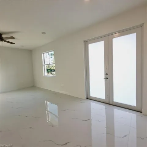Empty room with ceiling fan and french doors