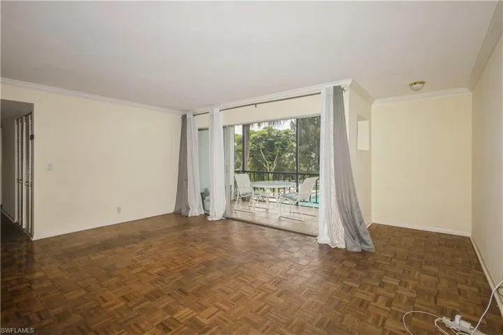 Empty room featuring dark parquet floors and crown molding