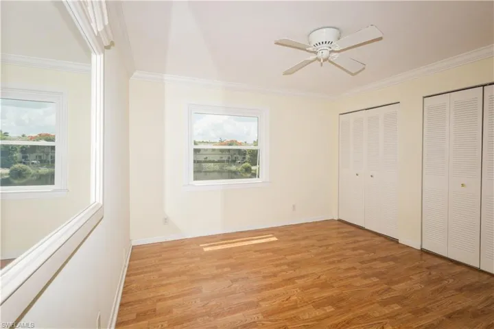 Master bedroom with crown molding, multiple windows, and light hardwood / wood-style flooring