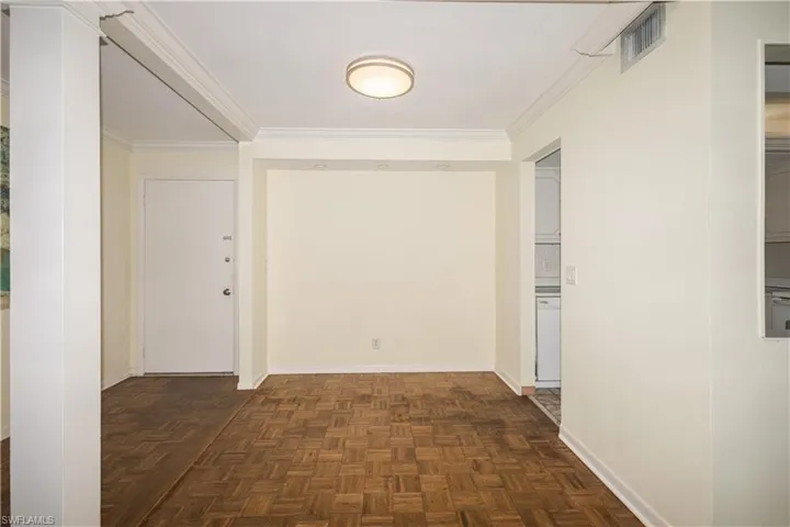 Corridor with dark parquet flooring and ornamental molding