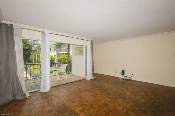 Empty room featuring dark parquet floors and crown molding