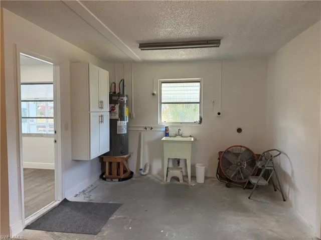 Garage featuring baseboards and water heater