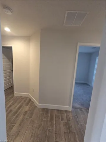 Corridor featuring wood finish floors and baseboards