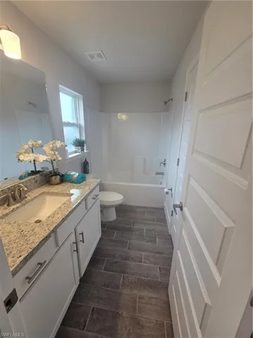 Bathroom featuring vanity, wood tiled floors, and washtub / shower combination