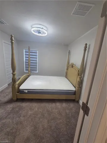 Carpeted bedroom with baseboards and a textured ceiling