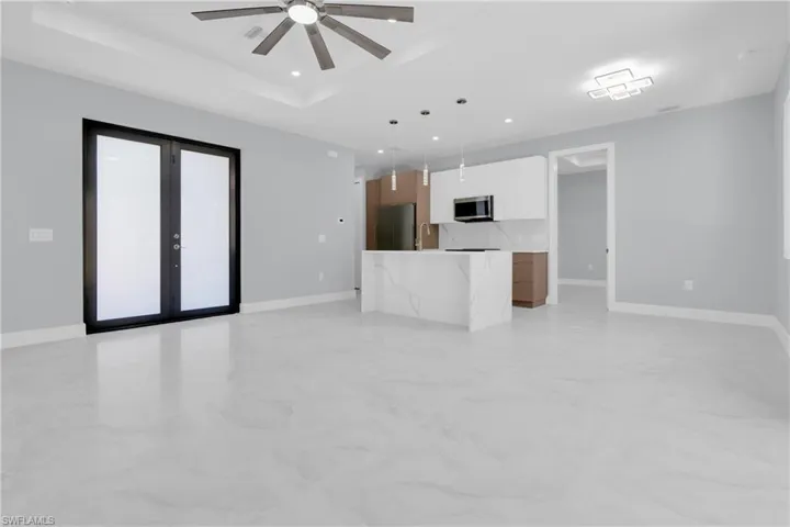 Unfurnished living room with french doors, a ceiling fan, and recessed lighting