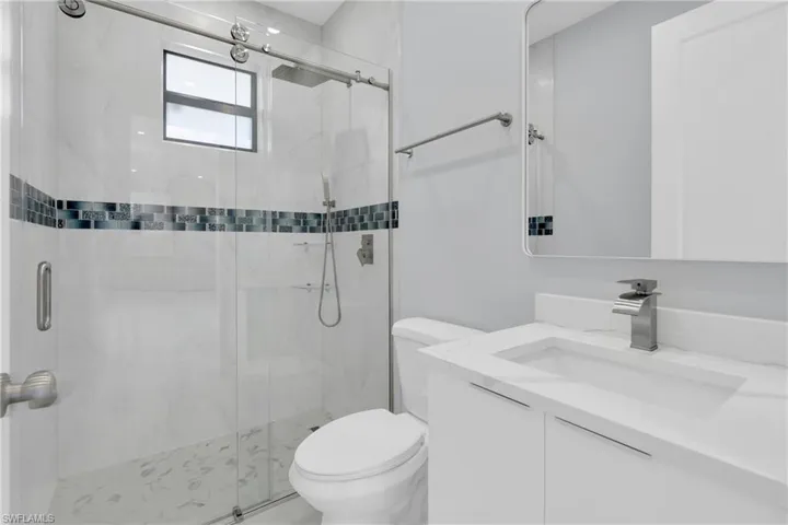 Full bath with vanity and a marble finish shower