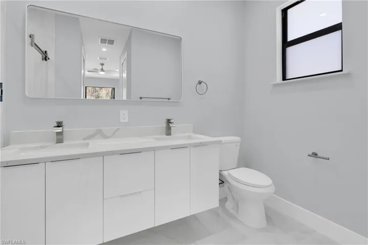 Full bath with double vanity and toilet