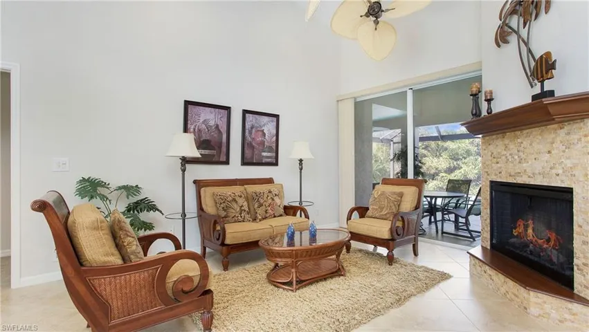 Sitting room featuring a lit fireplace, a high ceiling, and light tile patterned floors