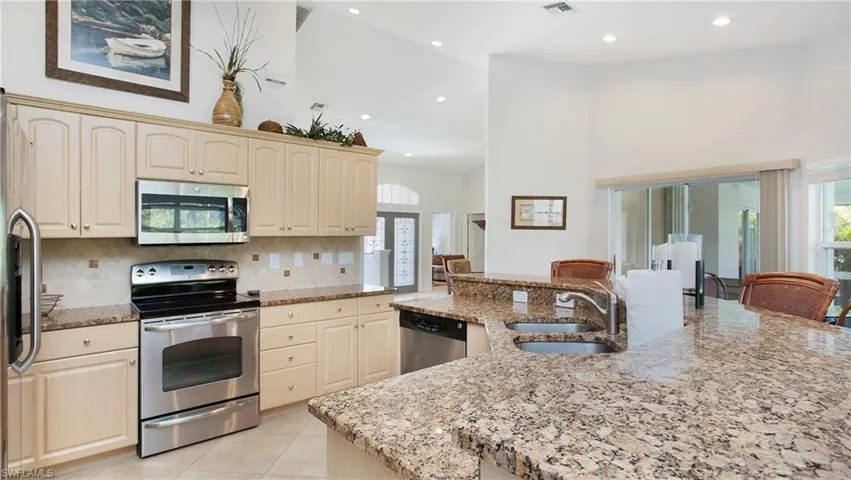 Kitchen with stainless steel appliances, light stone counters, light tile patterned floors, recessed lighting, and tasteful backsplash
