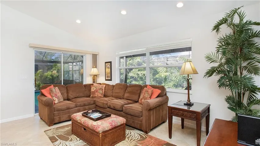 Living room with recessed lighting, vaulted ceiling, and light tile patterned floors