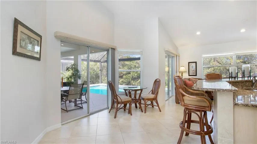 Dining area featuring a sunroom, a high ceiling, healthy amount of natural light, recessed lighting, and light tile patterned flooring