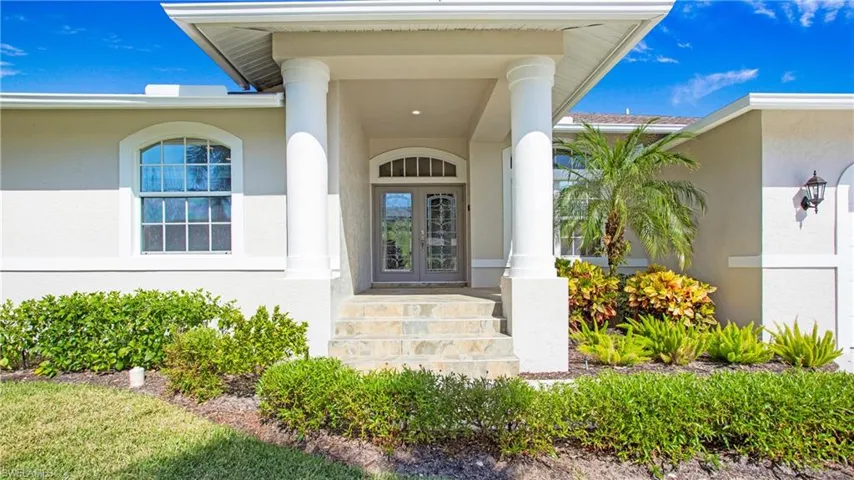 View of exterior entry featuring stucco siding, french doors, and covered porch