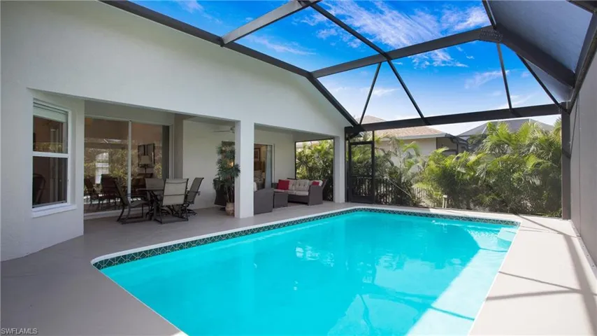 Outdoor pool with a sunroom, a lanai, an outdoor living / dining area, and a patio area