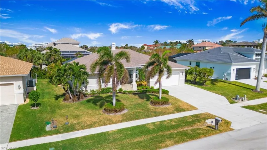 View of front of property with a front lawn, concrete driveway, and a residential view