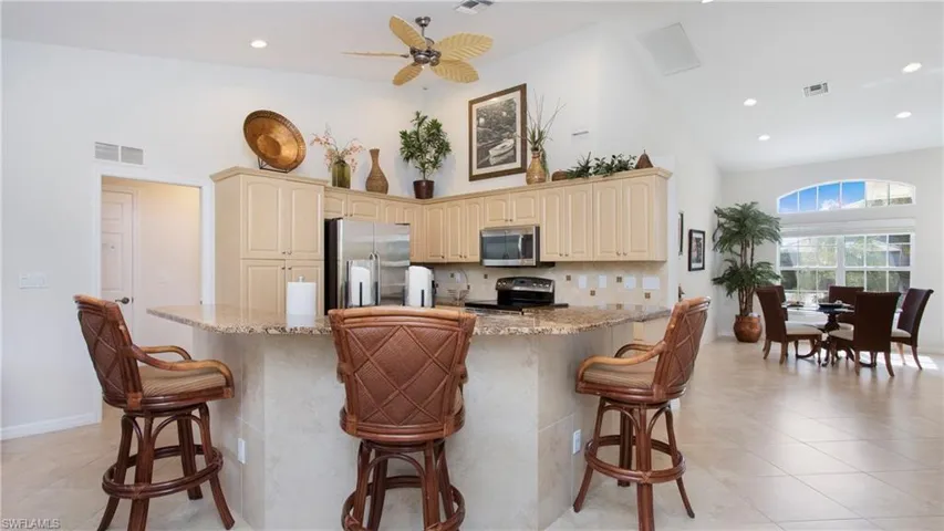 Kitchen with a ceiling fan, stainless steel appliances, backsplash, light stone counters, and recessed lighting