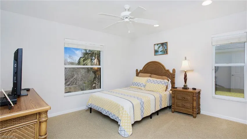 Carpeted bedroom with a ceiling fan and recessed lighting