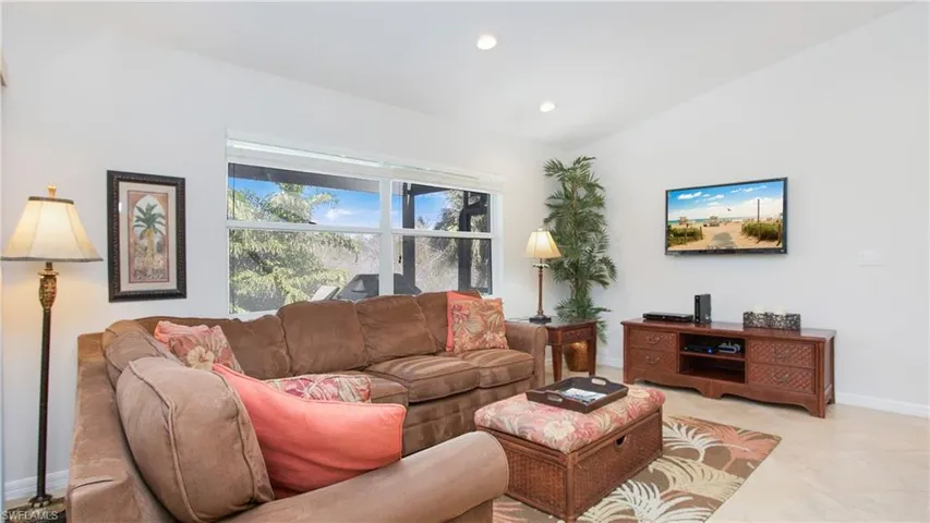 Tiled living room with vaulted ceiling and recessed lighting