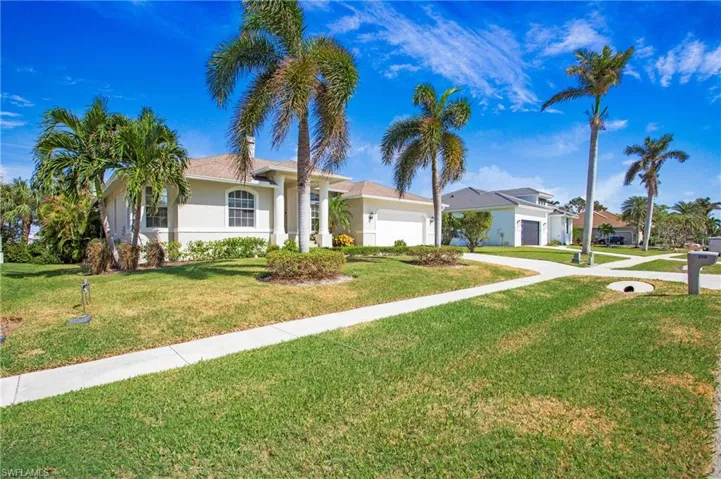 Single story home featuring a front lawn, a garage, driveway, and stucco siding