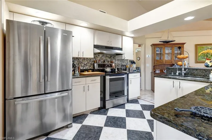 Kitchen featuring granite counters, sink, white cabinets, appliances with stainless steel finishes