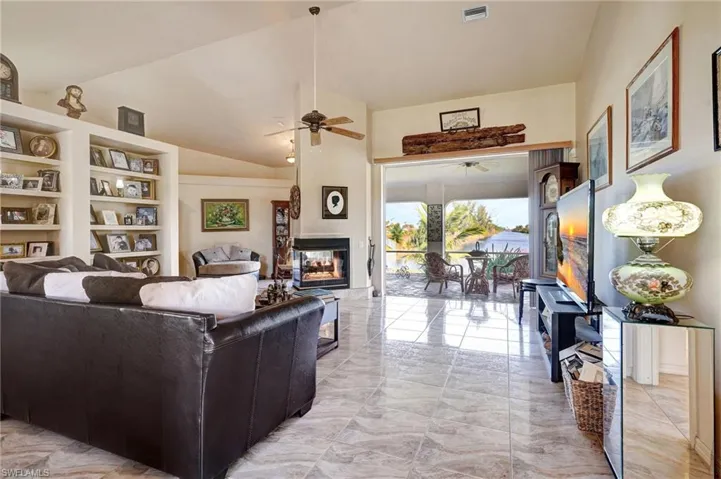 Living room featuring high vaulted ceiling, and a fireplace