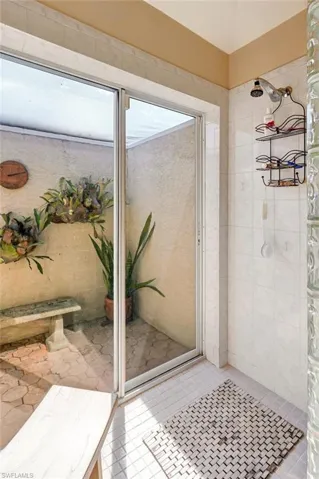 Atrium shower with tile patterned flooring and tiled shower