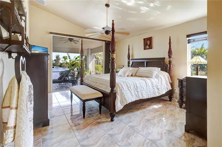 Bedroom with lofted ceiling, access to exterior, and ceiling fan