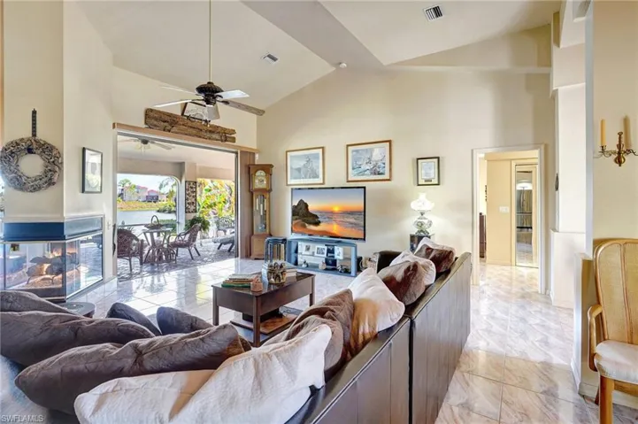 Living room featuring ceiling fan and high vaulted ceiling