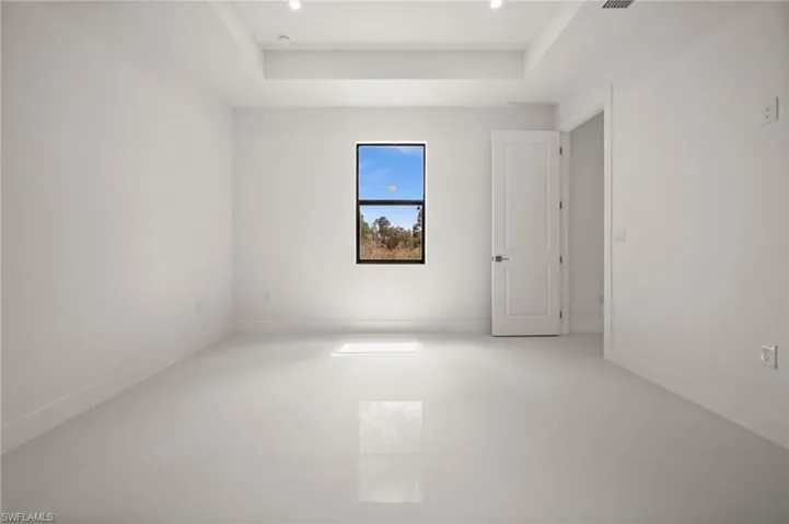 Spare room with a raised ceiling and baseboards