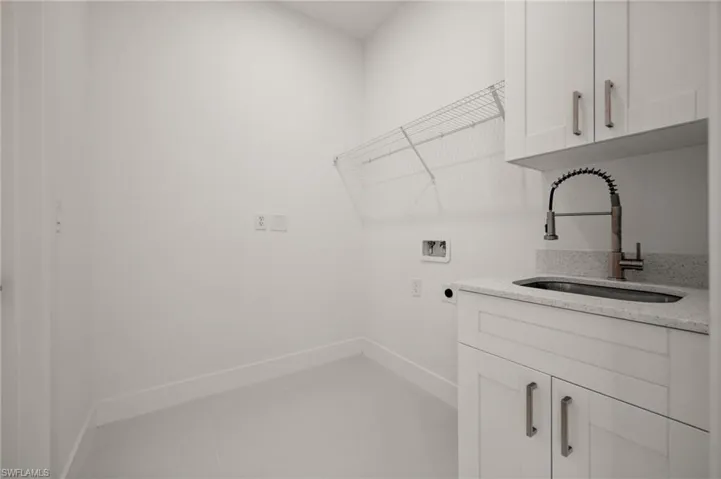 Laundry area featuring cabinet space, washer hookup, electric dryer hookup, and light tile patterned flooring