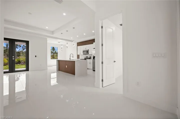 Unfurnished living room featuring recessed lighting and a raised ceiling