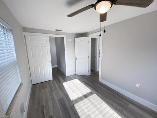 Unfurnished bedroom featuring dark wood-type flooring, a closet, and ceiling fan