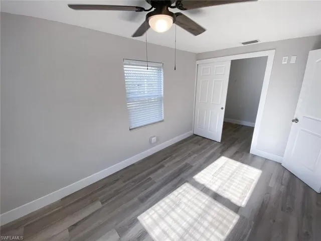 Unfurnished bedroom featuring a closet, ceiling fan, and dark hardwood / wood-style floors