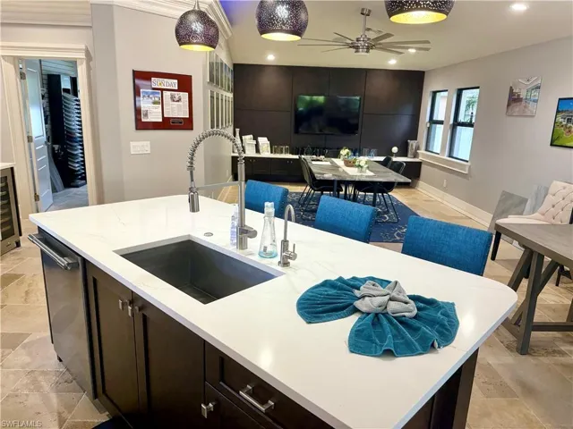 Kitchen featuring open floor plan, a ceiling fan, stone tile flooring, hanging light fixtures, and recessed lighting