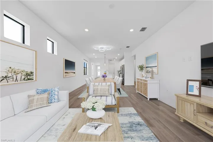 Expansive screened patio featuring a built-in outdoor kitchen with stainless steel grill, a ceiling fan, recessed lighting, and large sliding glass doors