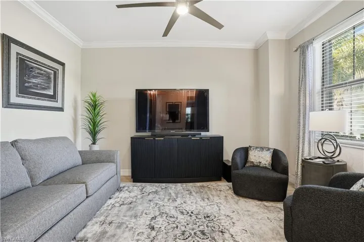 Living area with ornamental molding, ceiling fan, and wood finished floors