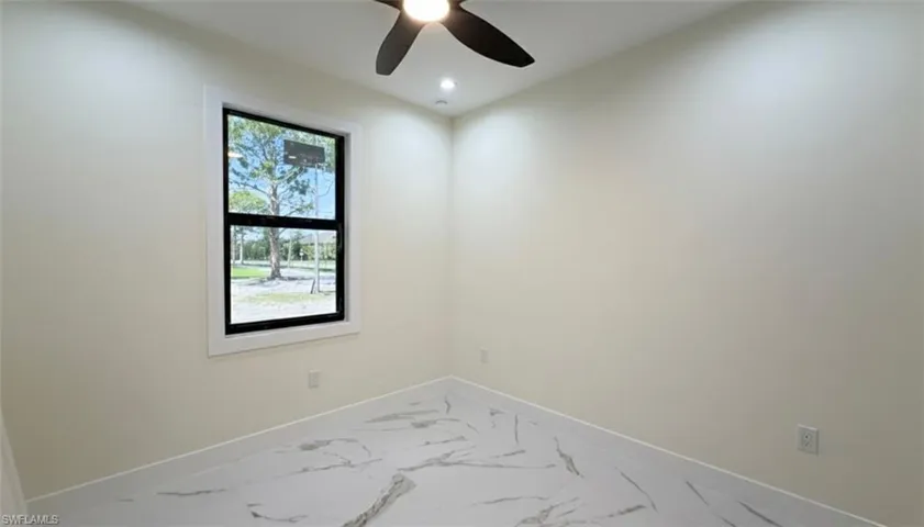 Unfurnished room featuring marble finish flooring and ceiling fan