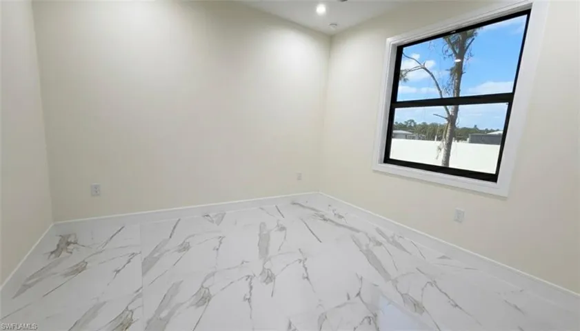 Spare room featuring marble look tile flooring and recessed lighting