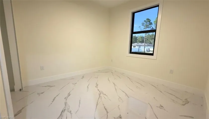 Spare room with baseboards and marble finish floors