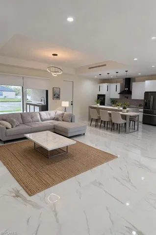 Living area with recessed lighting and a raised ceiling