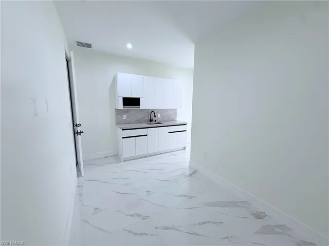 Corridor with light marble finish floors and baseboards