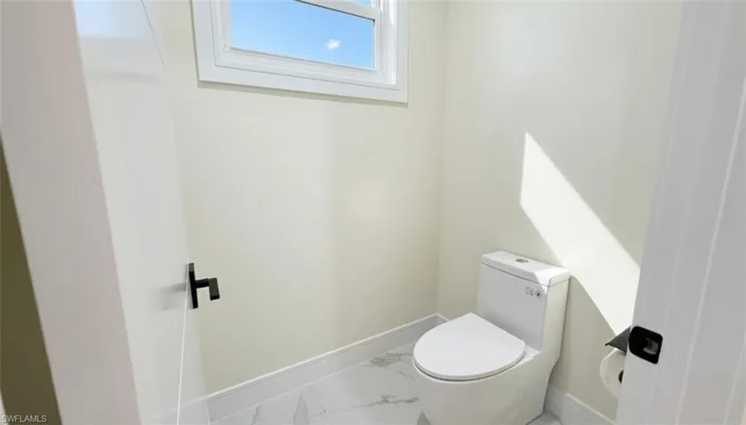 Bathroom with marble look tiles and baseboards