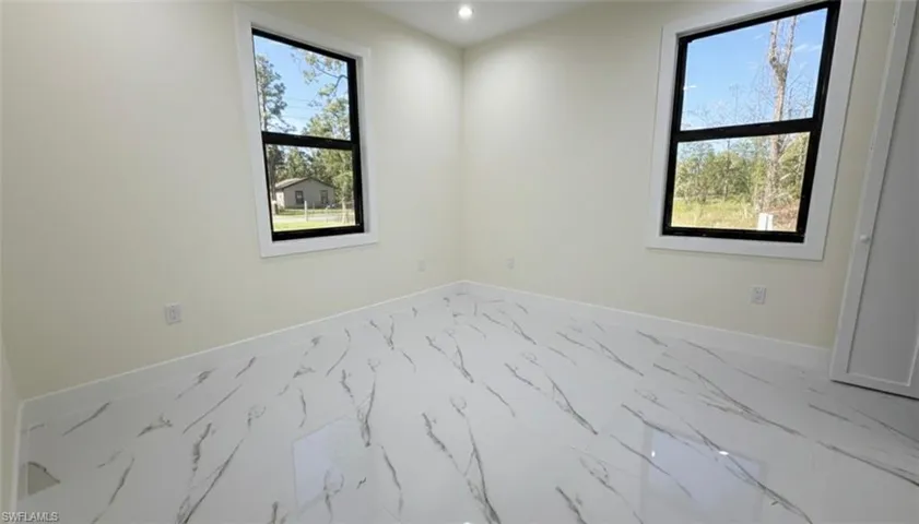 Unfurnished room with marble finish flooring and recessed lighting