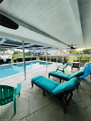 View of pool featuring a patio area and glass enclosure