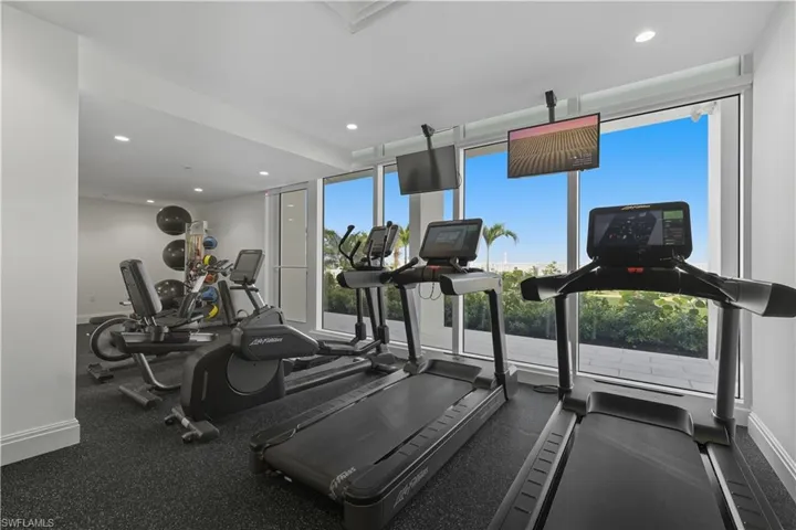 Gym with recessed lighting and expansive windows