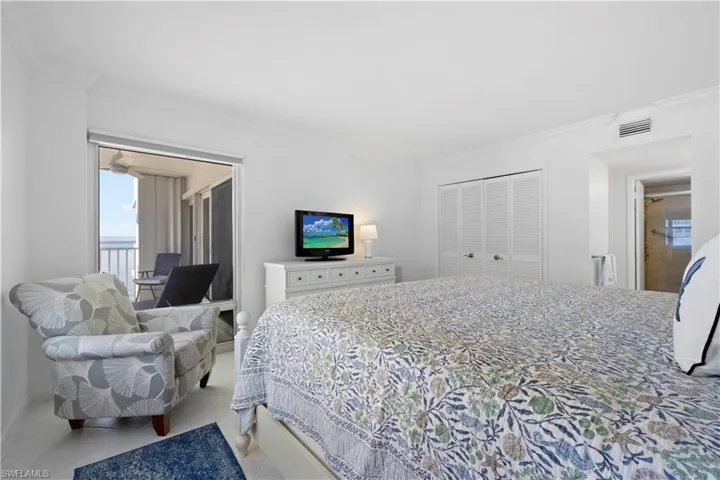 Bedroom featuring access to outside, multiple windows, crown molding, light tile patterned flooring, and a closet