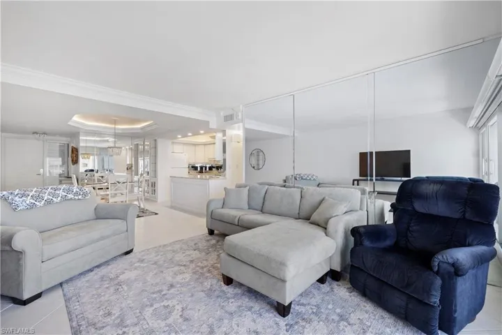 Living area with crown molding, tile patterned floors, and a tray ceiling